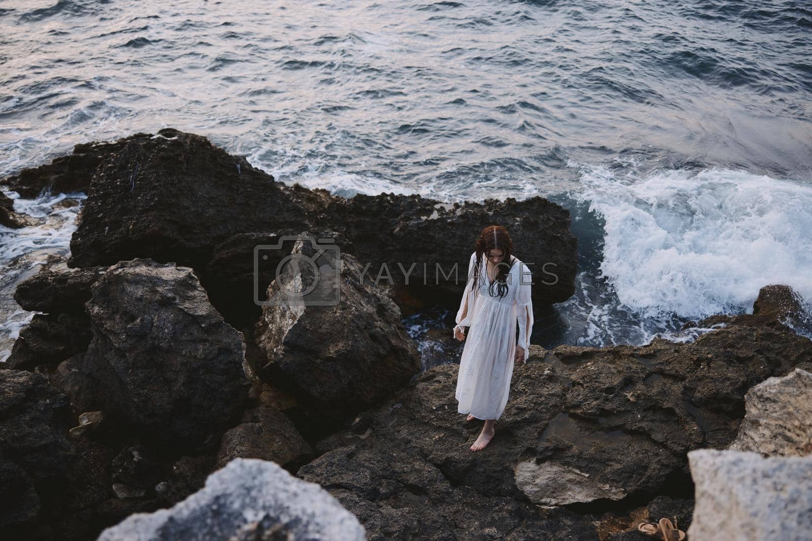 Woman in white dress rocks ocean nature travel. High quality photo