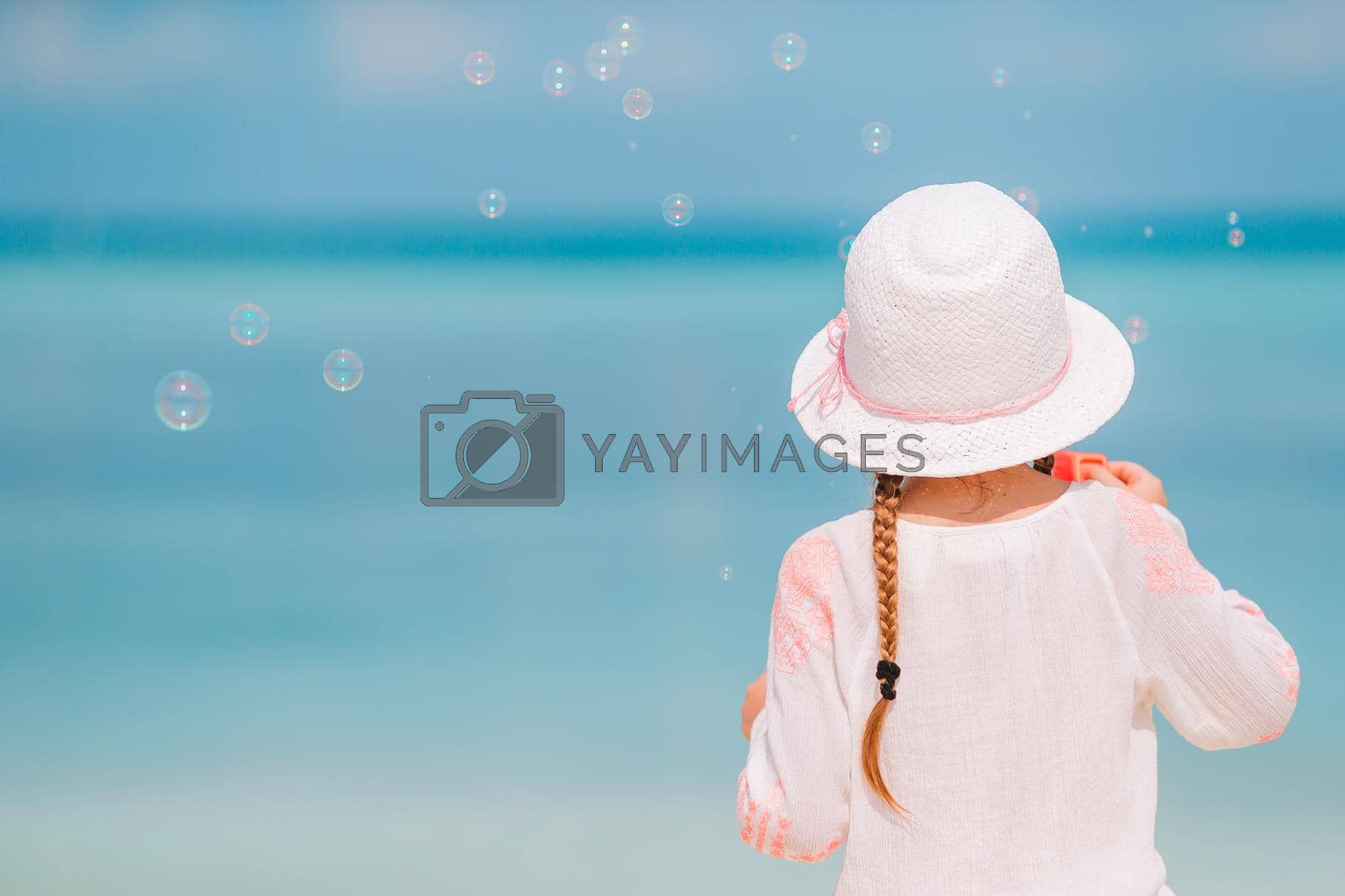 Royalty free image of Adorable little girl in hat at beach during summer vacation by travnikovstudio