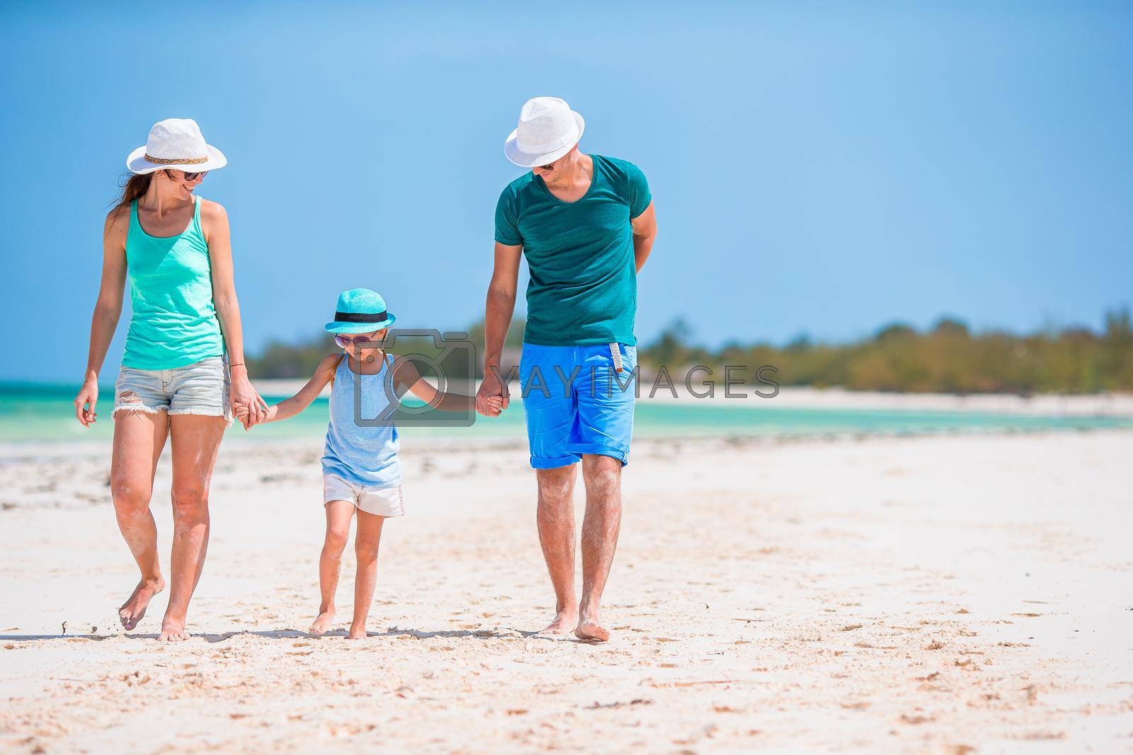 Royalty free image of Young family on white beach during summer vacation by travnikovstudio