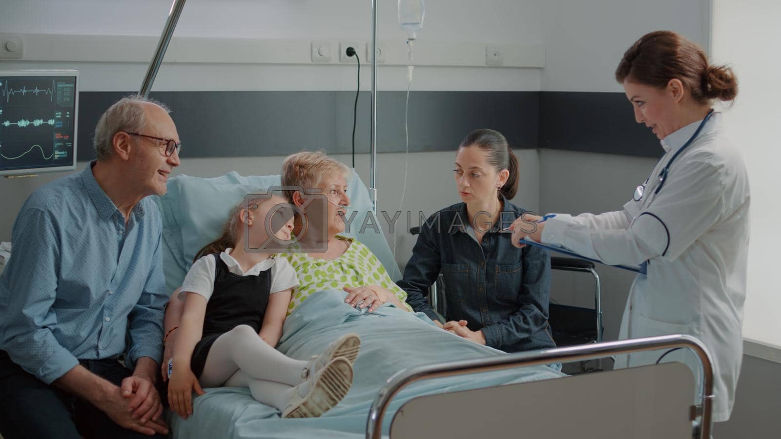 Sick grandma and family talking to physician about healthcare in hospital ward. Medical specialist explaining disease to senior patient in bed while she has visitors at clinic. Checkup visit