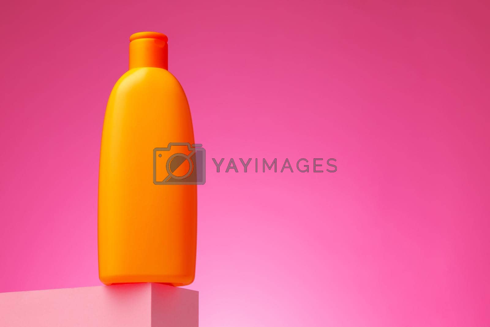 Skincare beauty products container against pink background, copy space