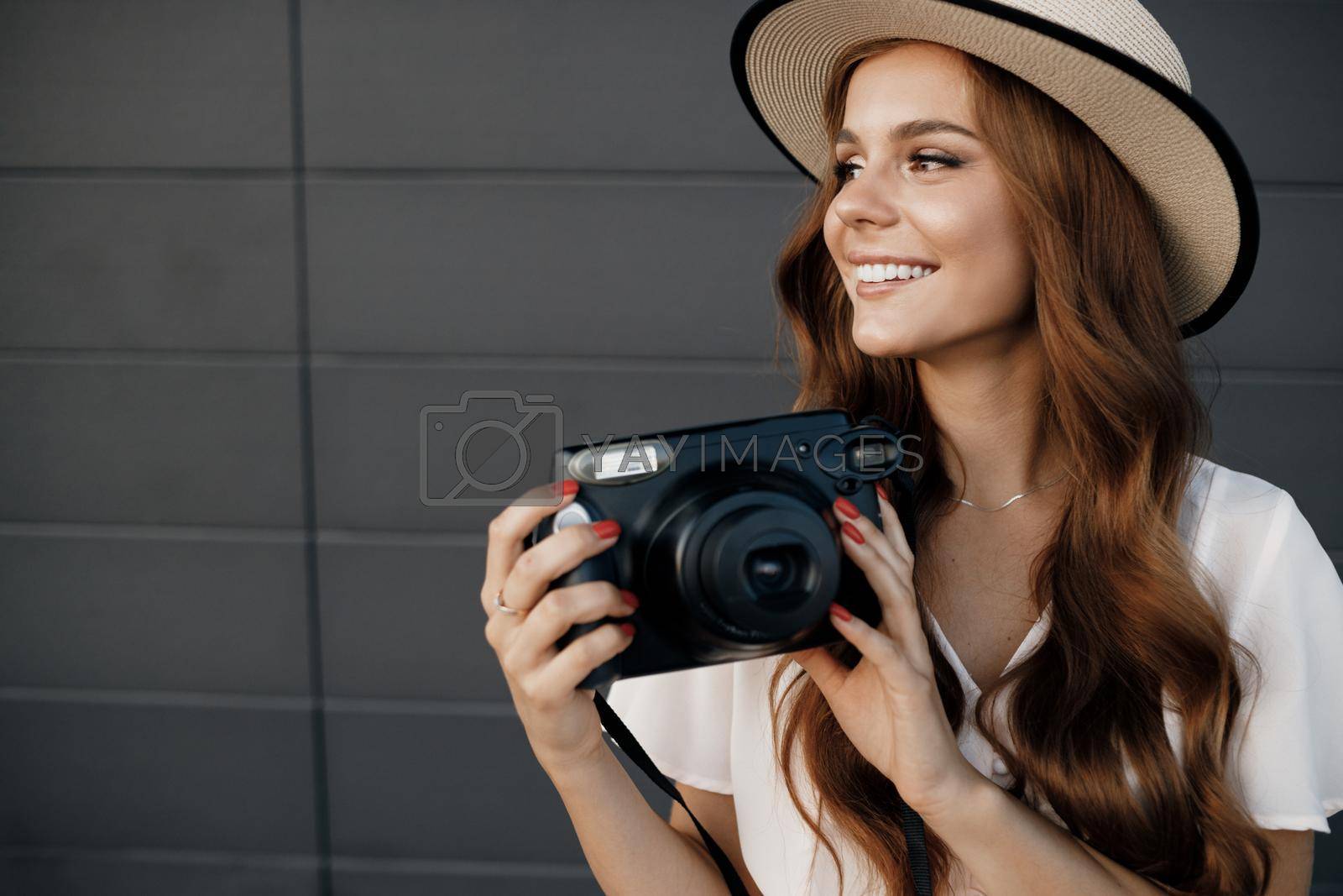 Royalty free image of happy young woman with camera outdoor by splash