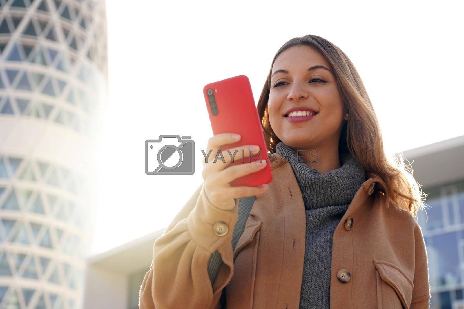 Business young beauty ethnic woman wearing coat using telephone walking outdoors