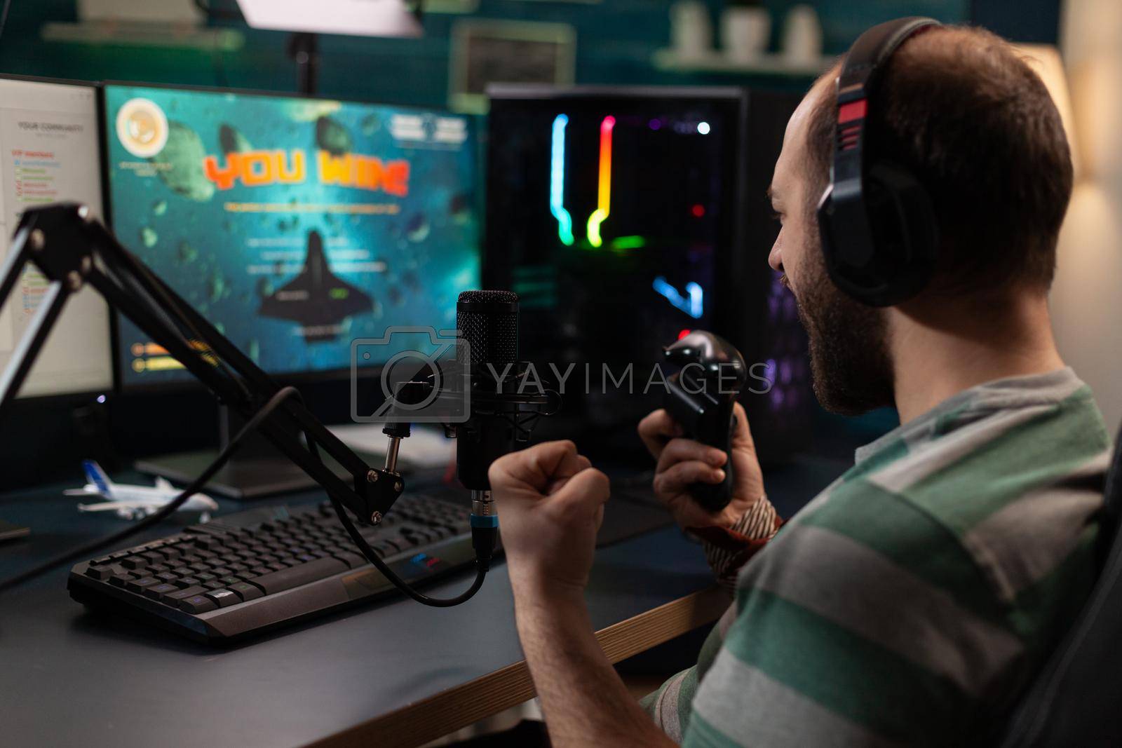 Royalty free image of Streamer winning video games with joystick on computer by DCStudio