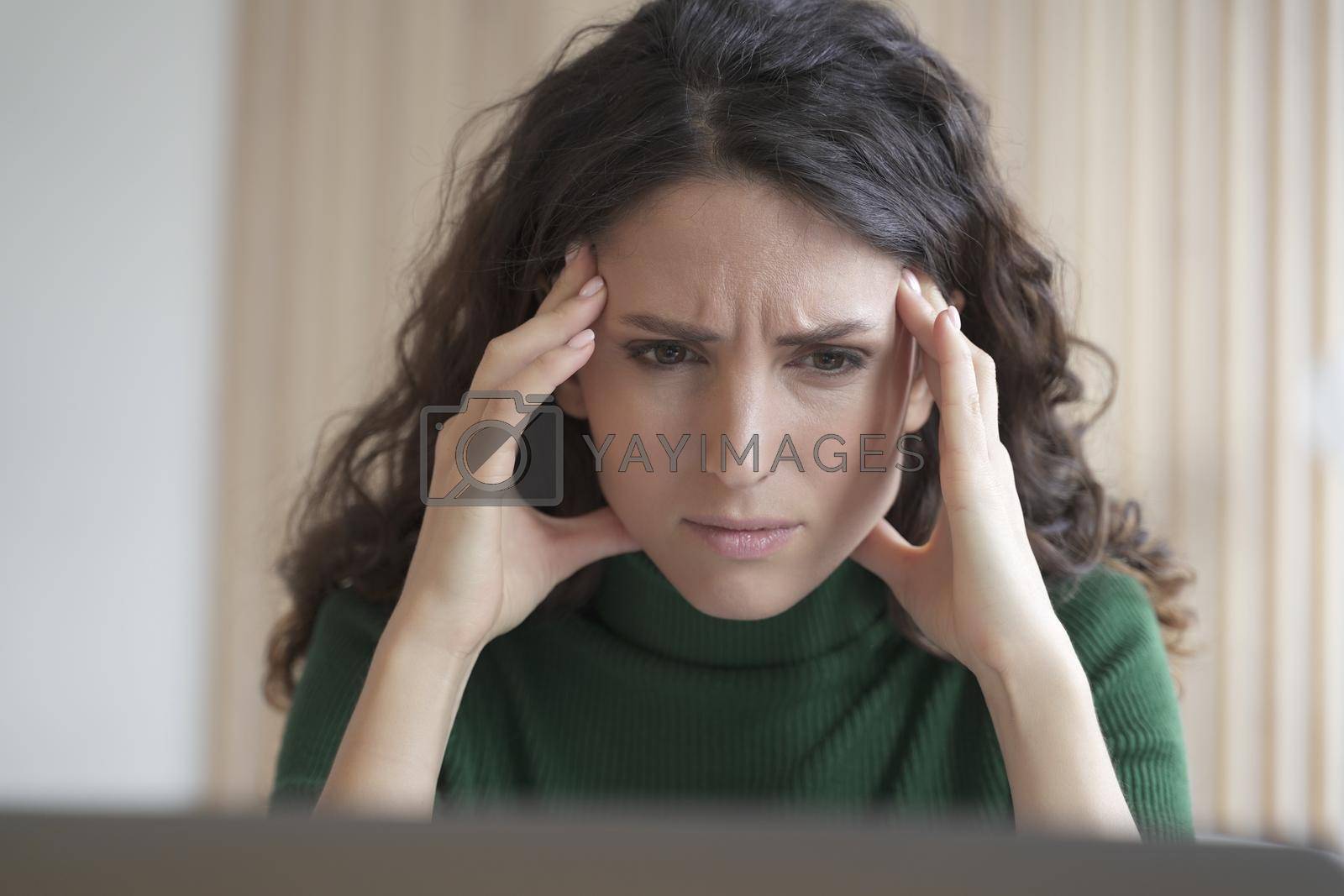 Royalty free image of Concerned young italian woman employee looking at computer screen with frustrated face expression by vkstock