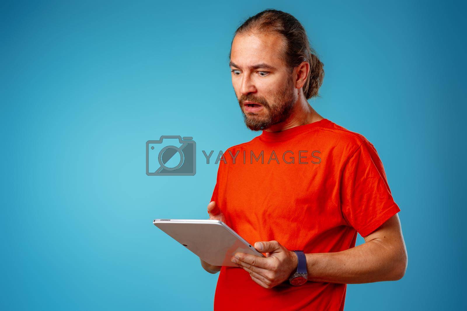 Royalty free image of Funny hipster man using his digital tablet by Fabrikasimf
