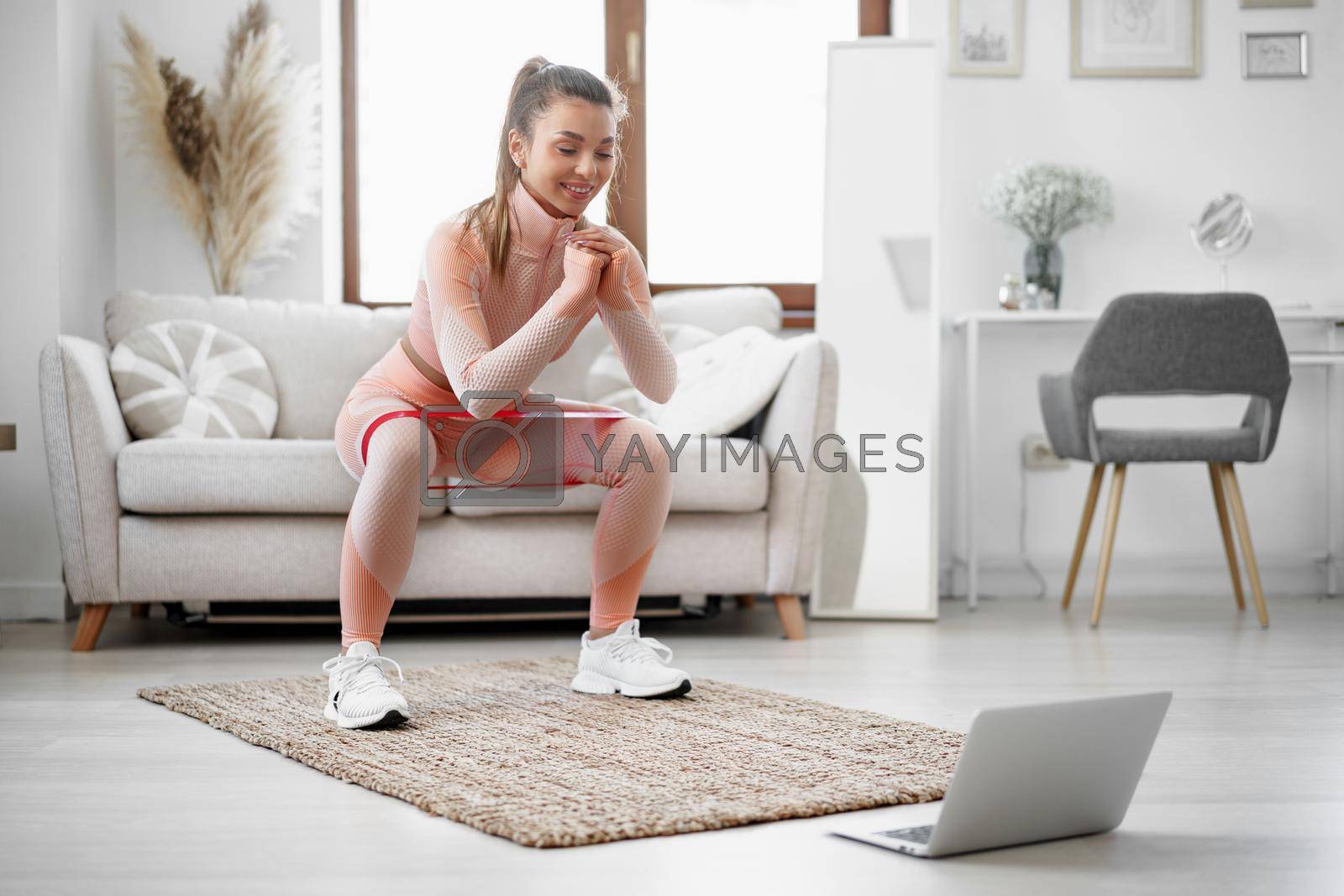 Young fitness girl doing sport exercises at her living room at home, close up