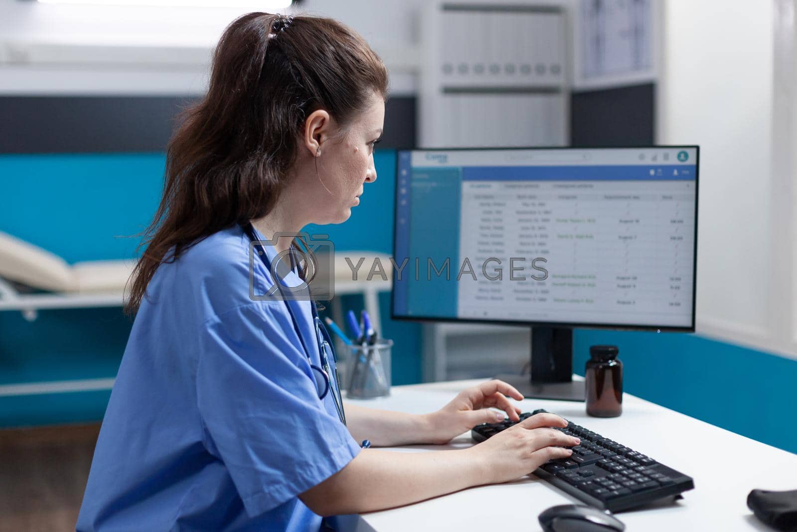Royalty free image of Practitioner specialist nurse analyzing medical examination using computer by DCStudio