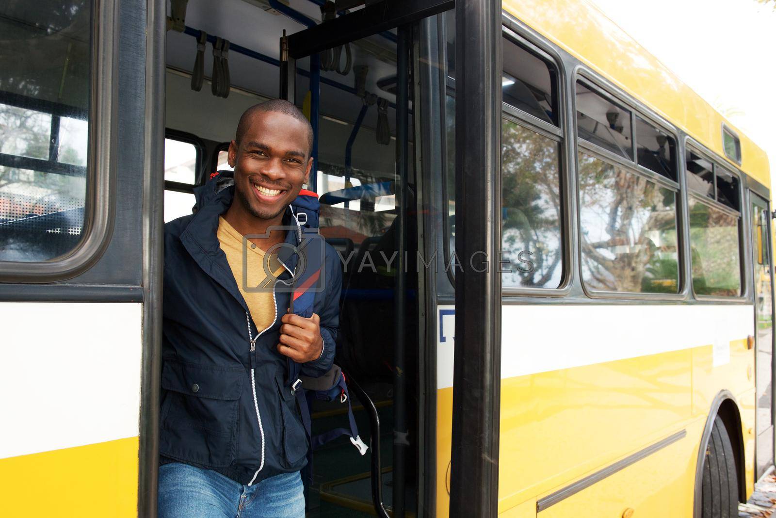 Portrait of happy young african american travel man with bag getting off bus