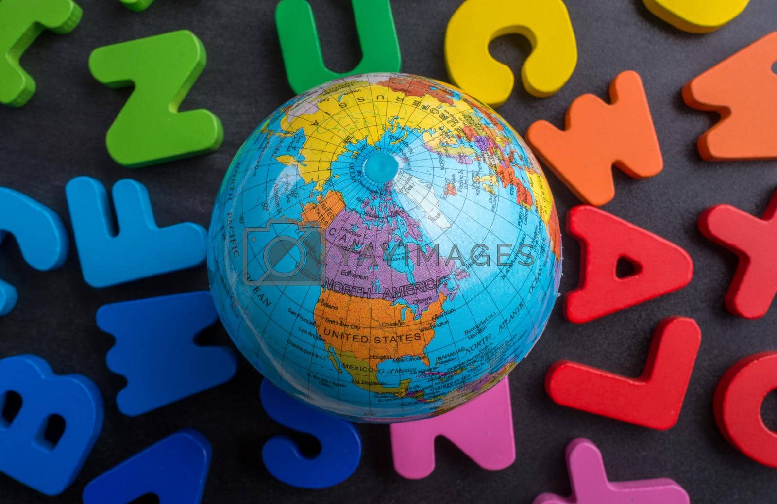Royalty free image of Globe model on colorful letters on a black background by berkay