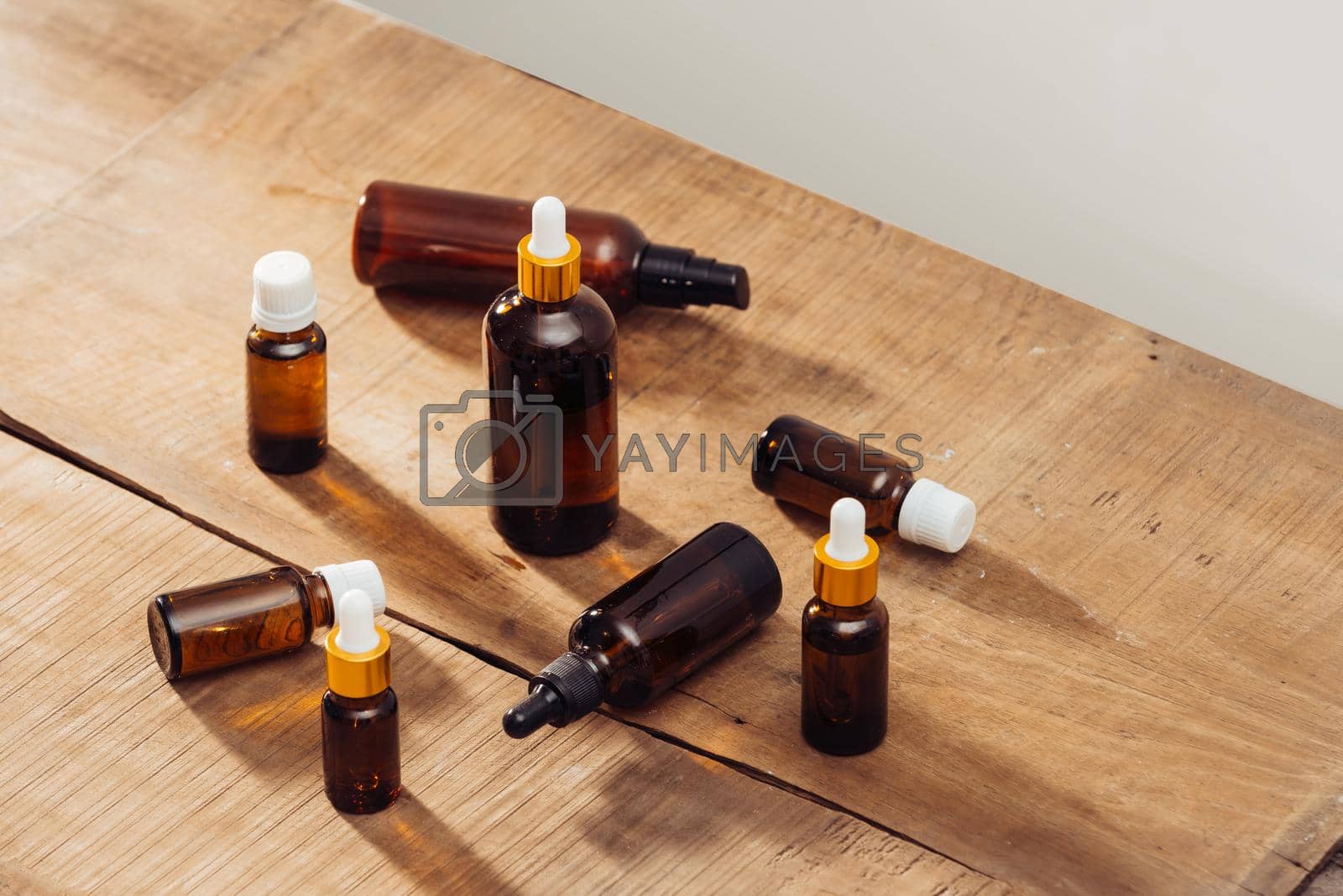 Royalty free image of Essential oils bottles on wooden desk with candlelight beside. Spa wellness set. by makidotvn