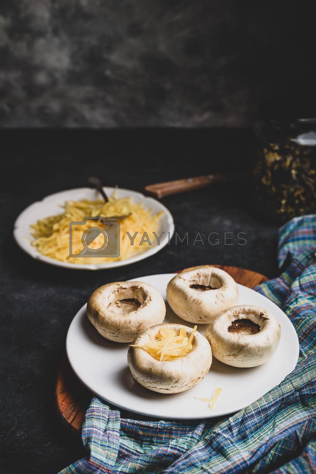 Royalty free image of Stuffing mushrooms with grated cheese by Seva_blsv