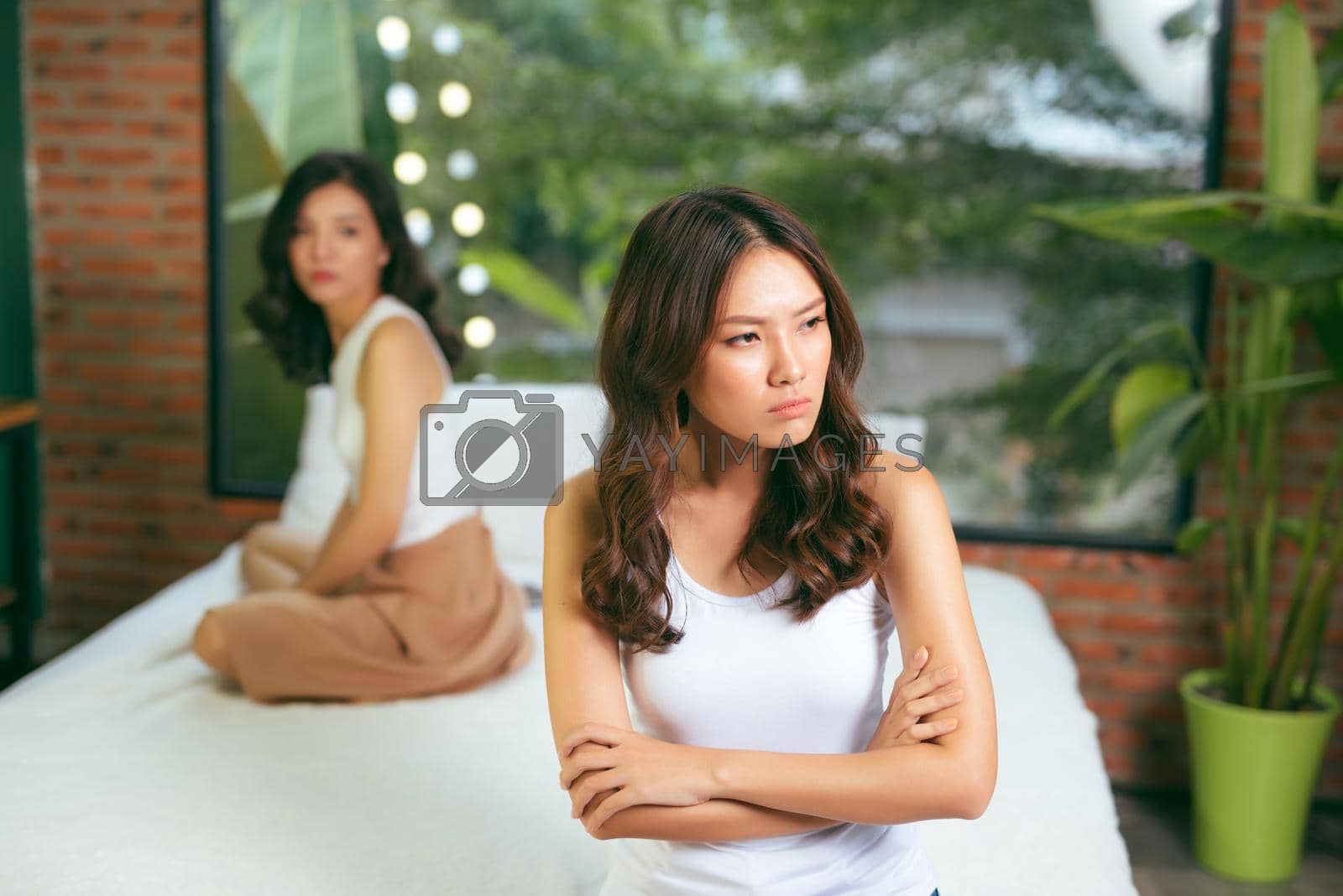 Royalty free image of Two young beautiful women angry with each other at home by makidotvn