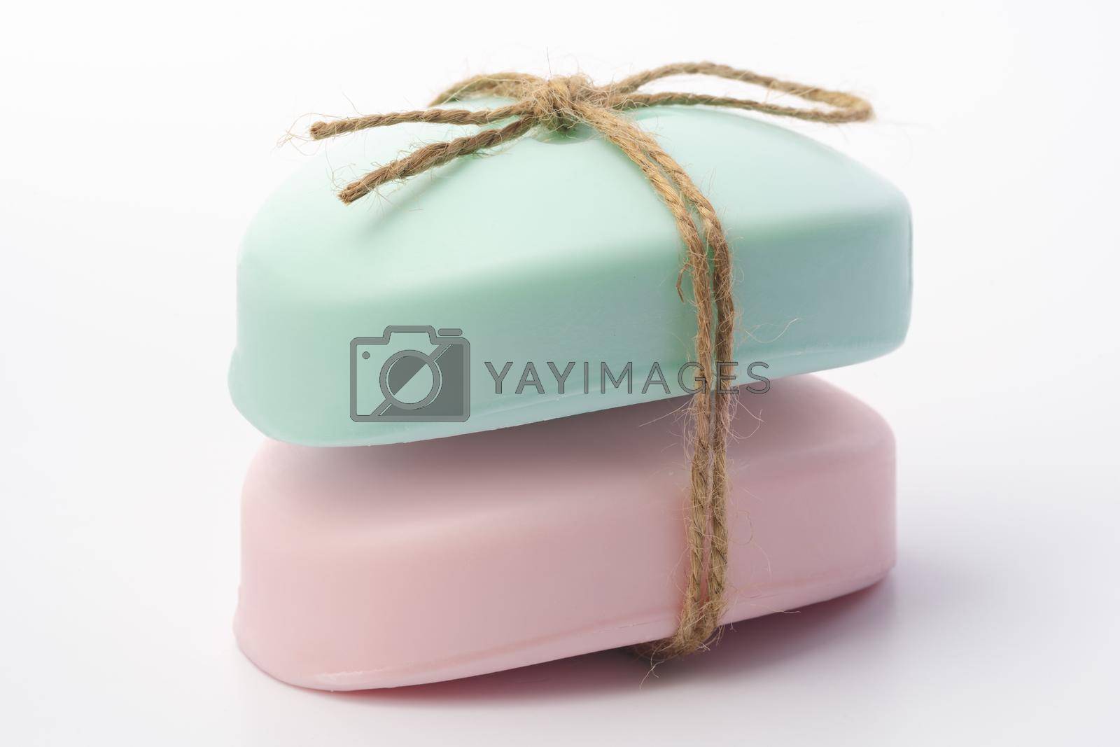 Royalty free image of Two pieces of soap tied with a ribbon on a white background by Fabrikasimf