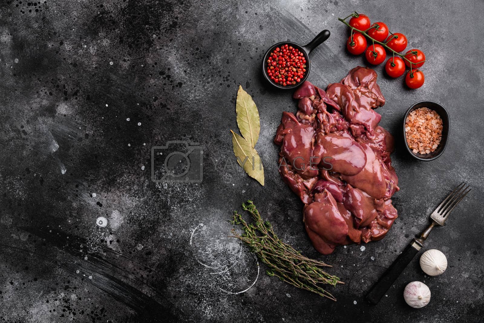 Royalty free image of Fresh duck liver offal, on black dark stone table background, top view flat lay, with copy space for text by Ilianesolenyi