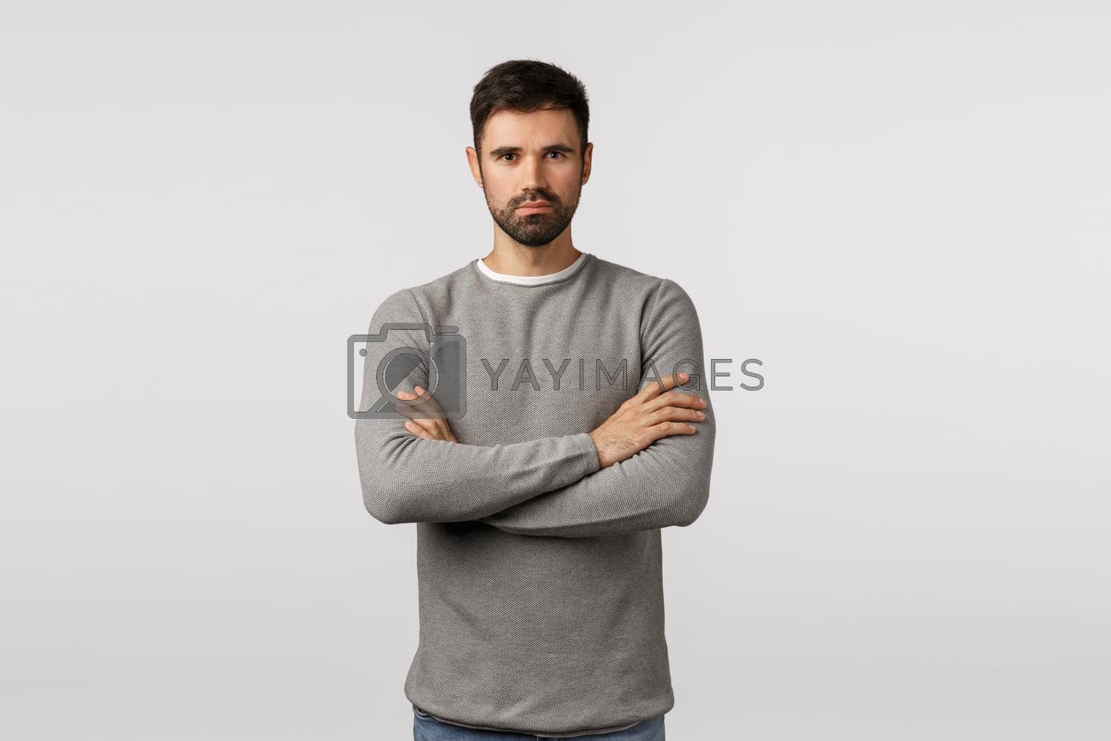 Royalty free image of Confidence, courage and motivation concept. Serious-looking handsome strong serious bearded man in grey sweater, look professional and determined, cross arms over chest, assertive ready pose by Benzoix