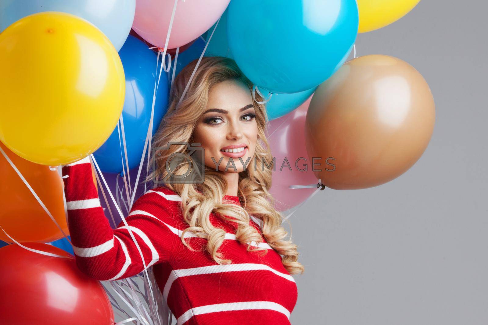Royalty free image of Happy woman with many colorful balloons by Yellowj