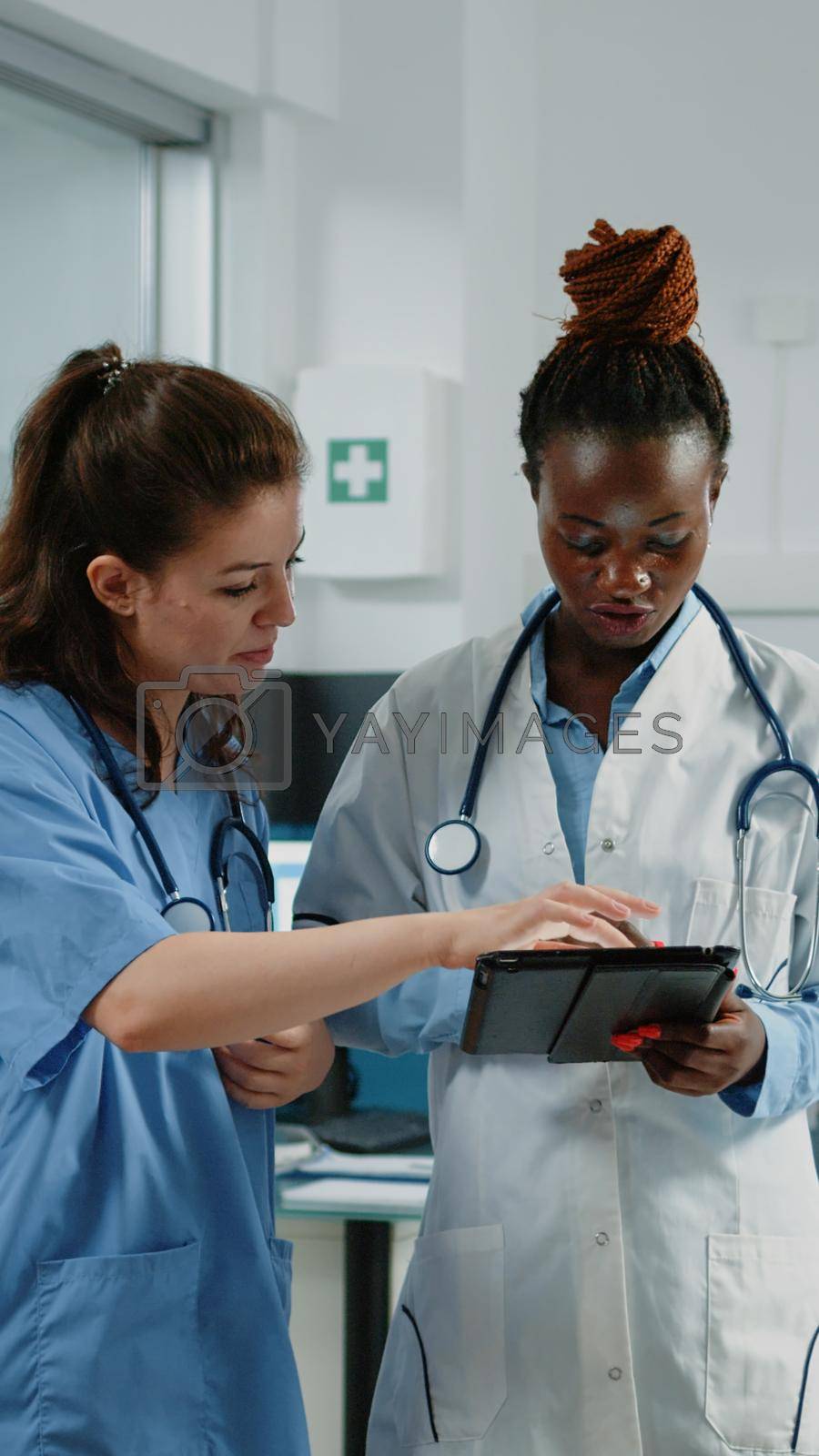 Doctor and nurse working with tablet for healthcare system in cabinet. Medical team of medic and assistant using technology for examination and treatment. Specialists in doctors office