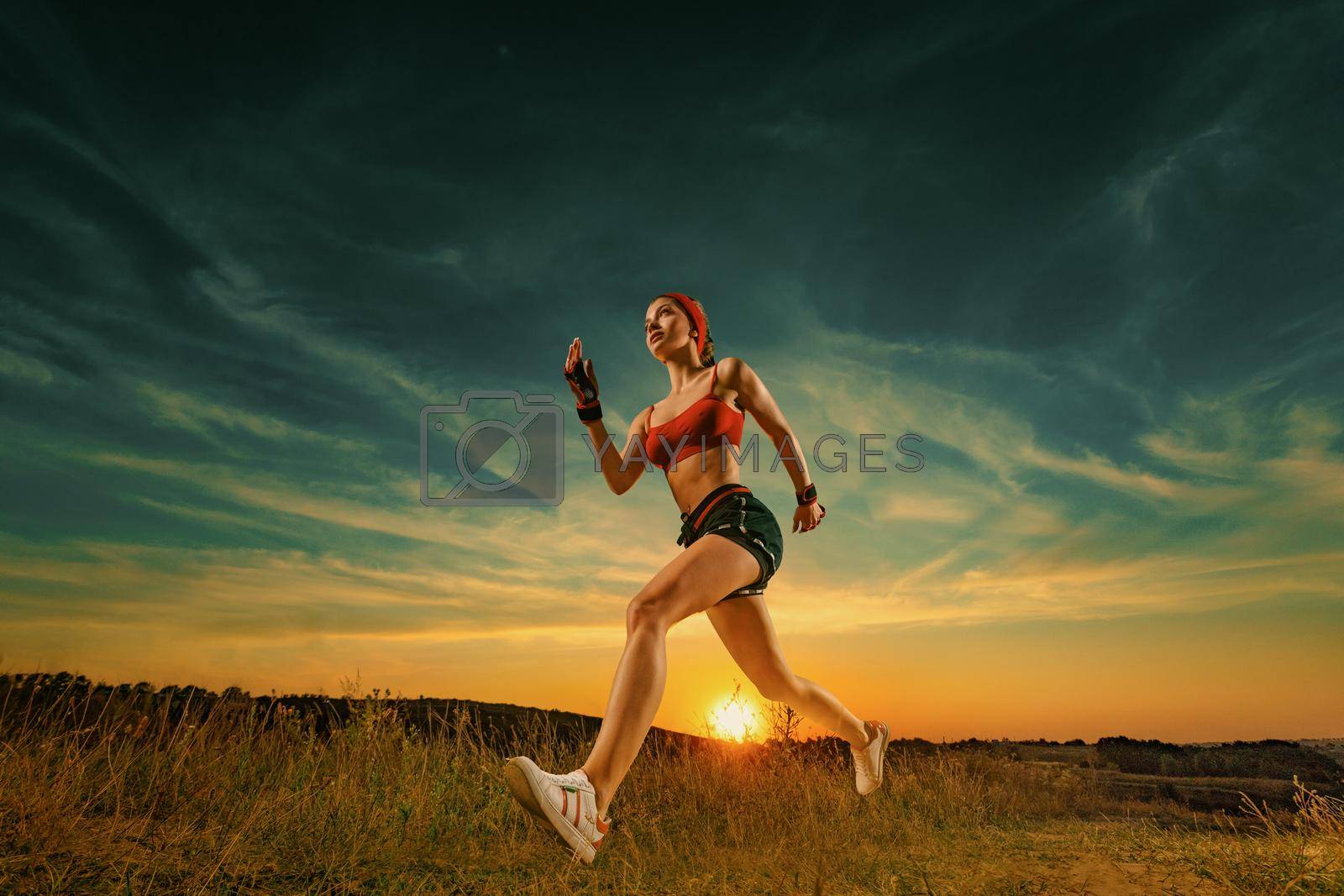 Royalty free image of Runner running on trail. Athlete sprinter run. Strong athletic woman running on black background wearing in the sportswear. Fitness and sport motivation. Runner concept. by MikeOrlov