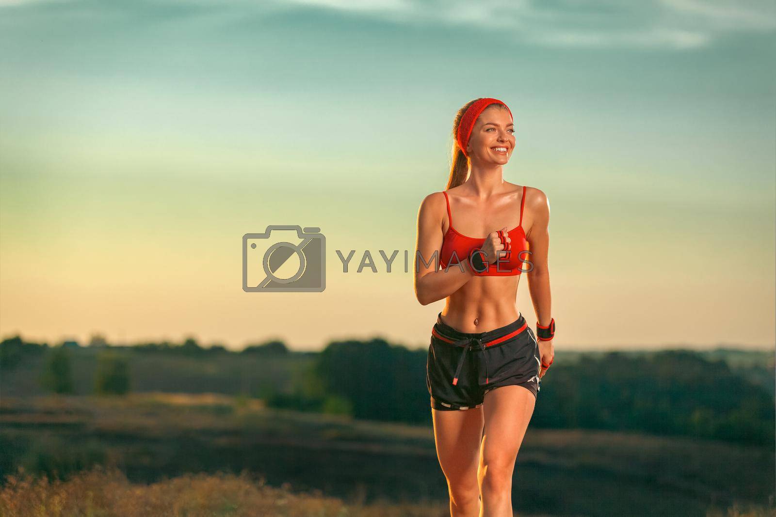 Royalty free image of Happy and smiling woman athlete and runner running on trail. Fitness and sport motivation. by MikeOrlov