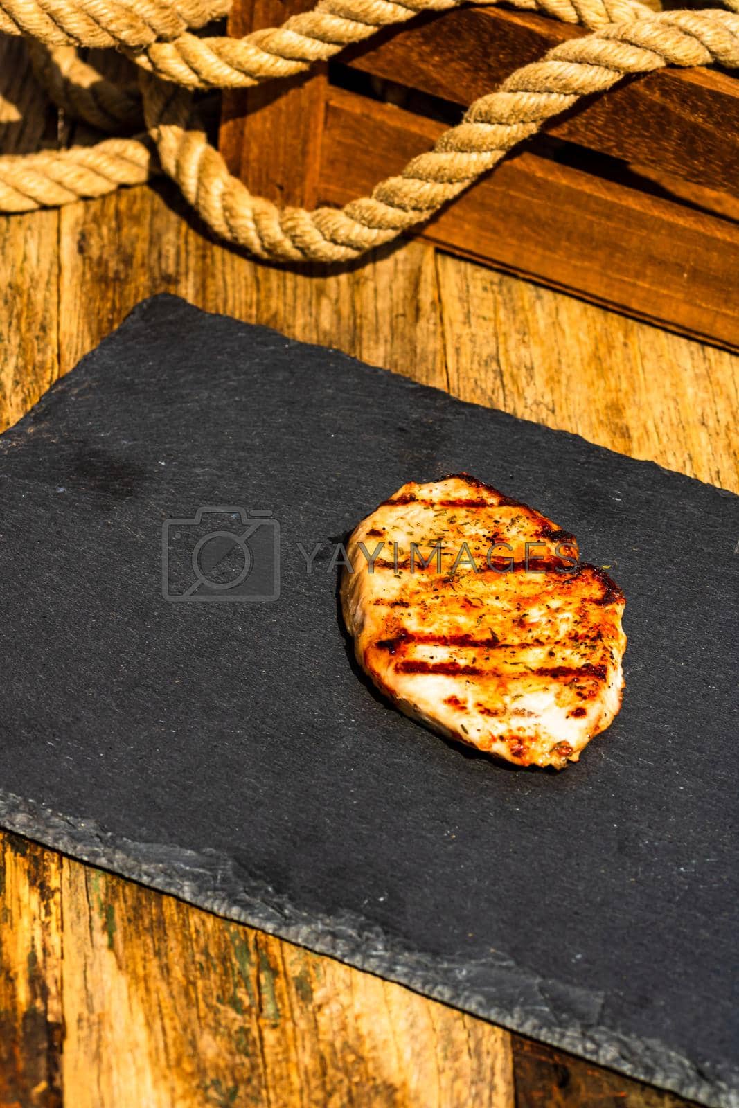 Royalty free image of Detail of tasty pork steak on rustic background by vladispas