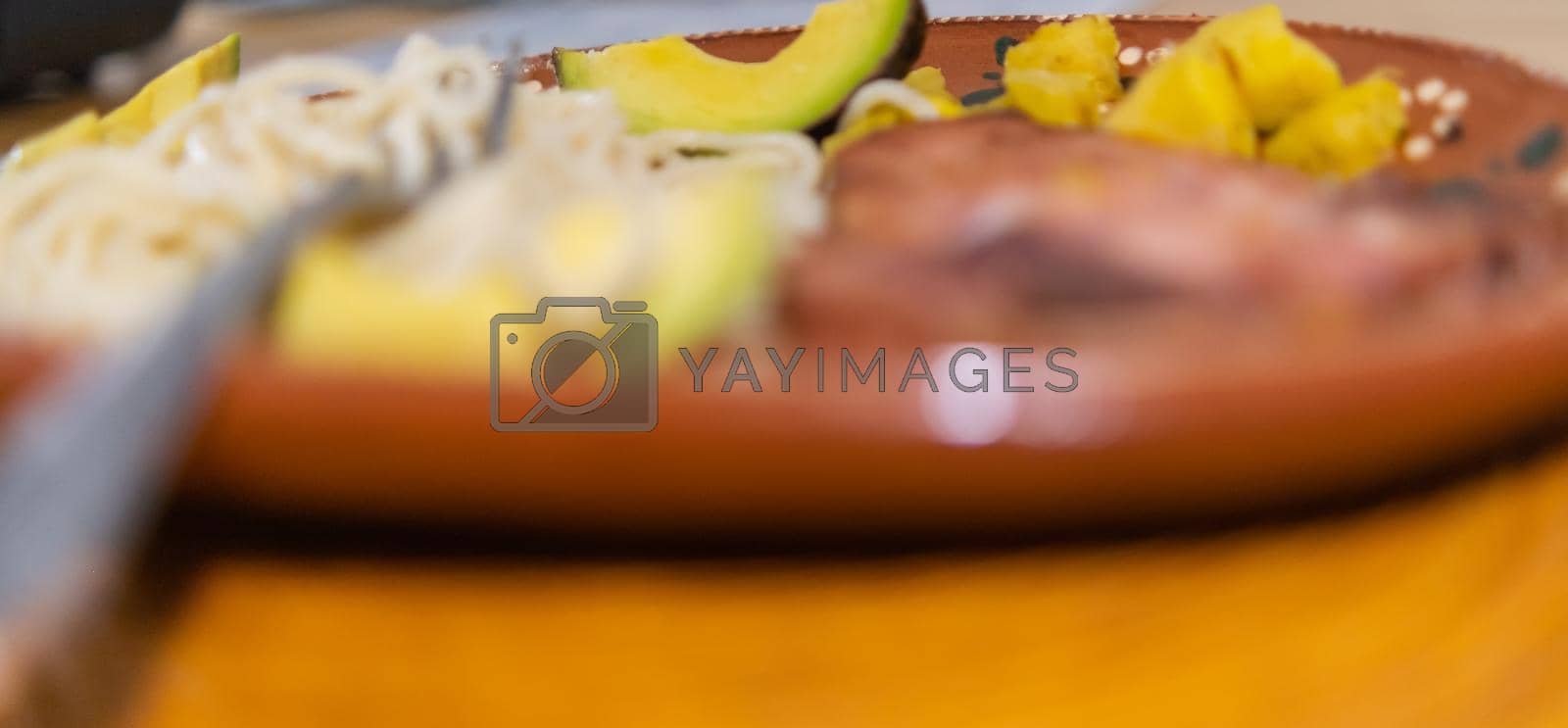 Royalty free image of White spaghetti and porkchop on traditional clay plate by Kanelbulle