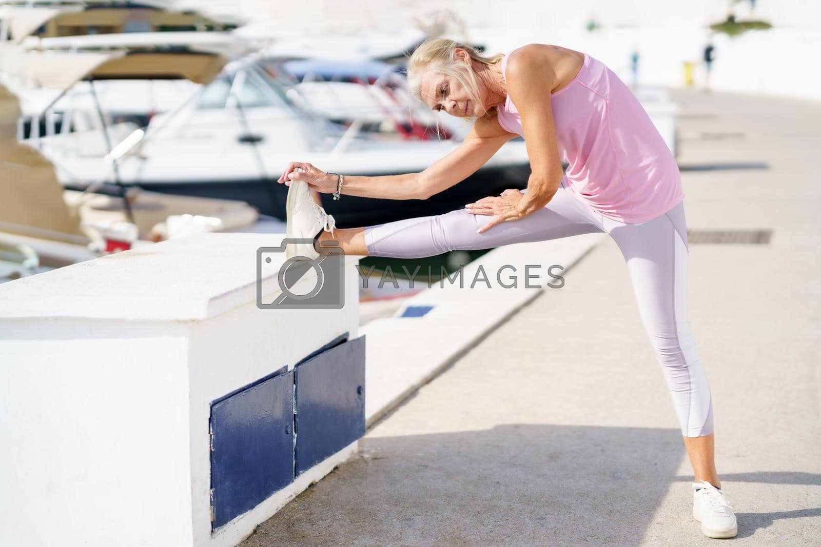 Royalty free image of Mature sportswoman stretching her legs after exercise. by javiindy