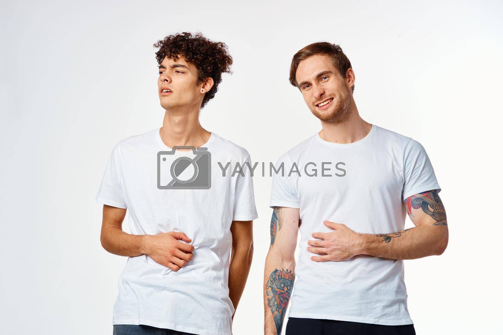 two men in t-shirts friendship communication light background. High quality photo