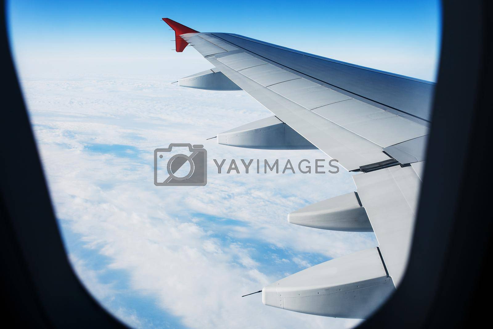View of the jet aircraft wing, blue sky, clear weather