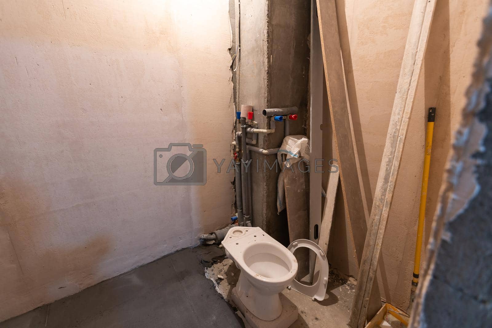 Royalty free image of Toilet bowl in the bathroom. Repair. Sanitary ceramics. Plumbing. Water pipes. Plastic faucet. Floor standing toilet. by Andelov13