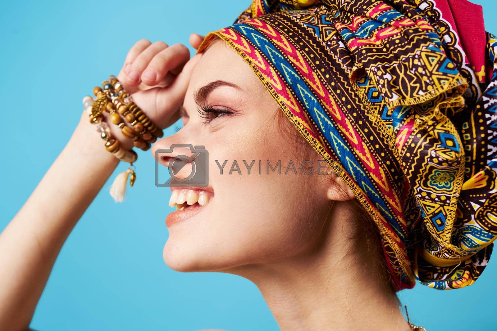 Royalty free image of beautiful woman ethnicity multicolored headscarf makeup glamor isolated background by SHOTPRIME