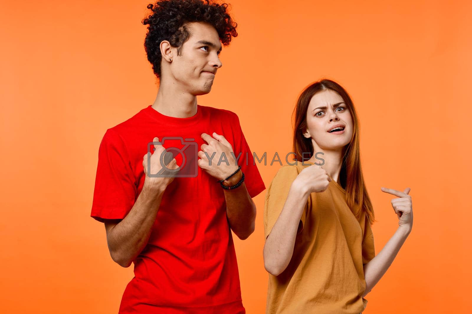 young couple fun friendship communication orange background fashion. High quality photo