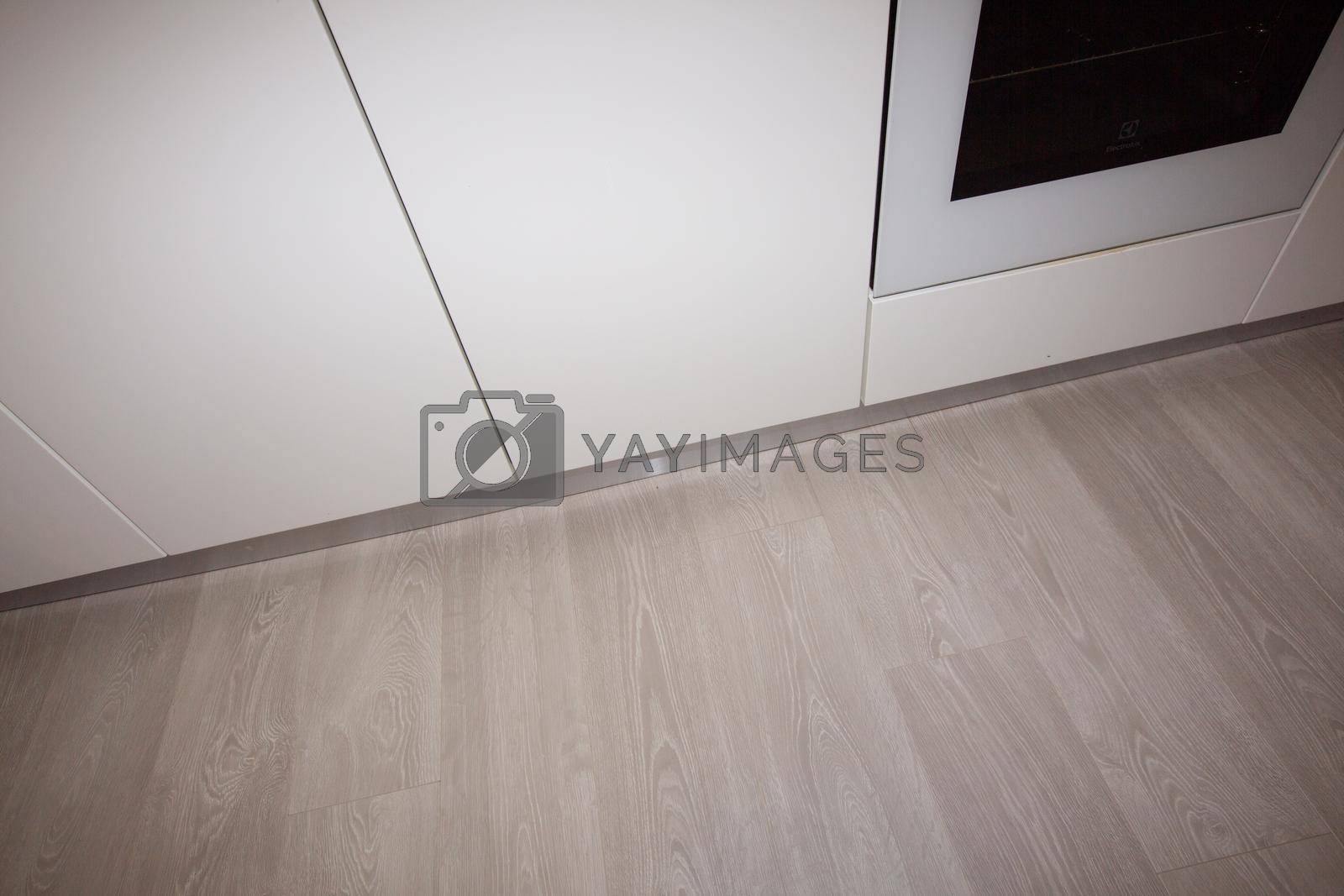 Royalty free image of New kitchen in renovated house with laminated timber flooring by Andelov13