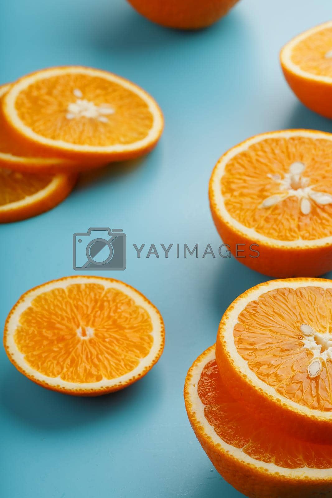 Royalty free image of Slices and slices of orange pulp on a bright blue background as a textural background, the substrate. Full screen Flat lay, top view. Food background by AlexGrec