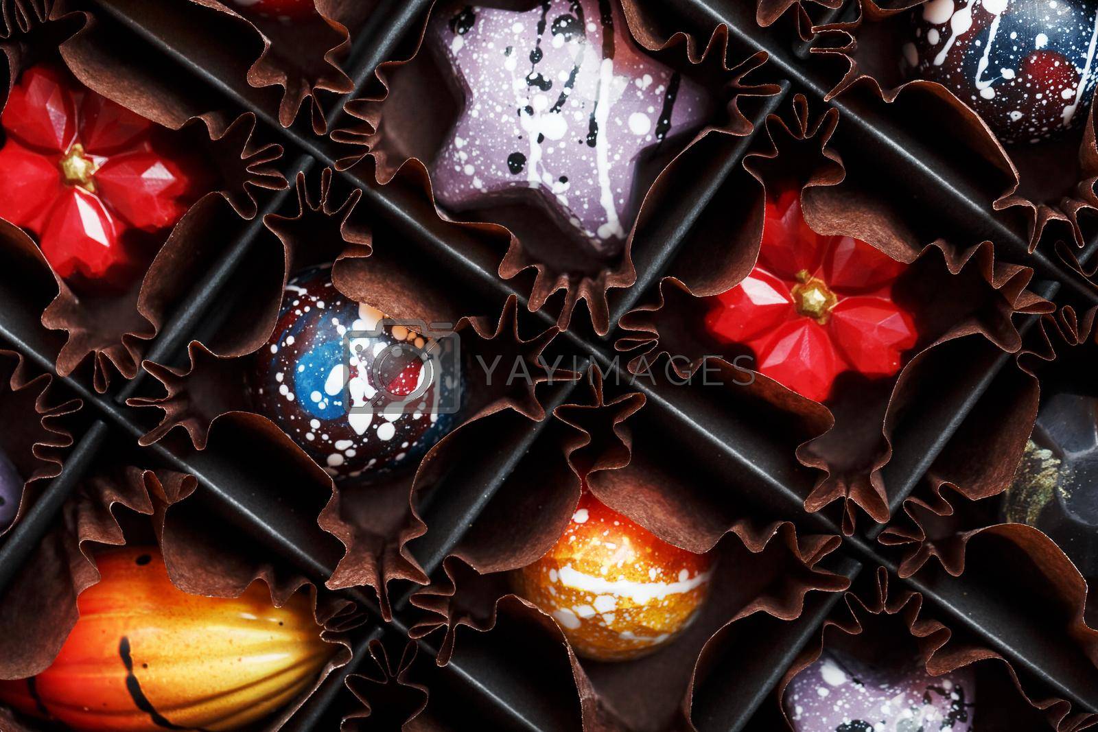 Royalty free image of A set of colorful exclusive handmade chocolates in a package. by AlexGrec