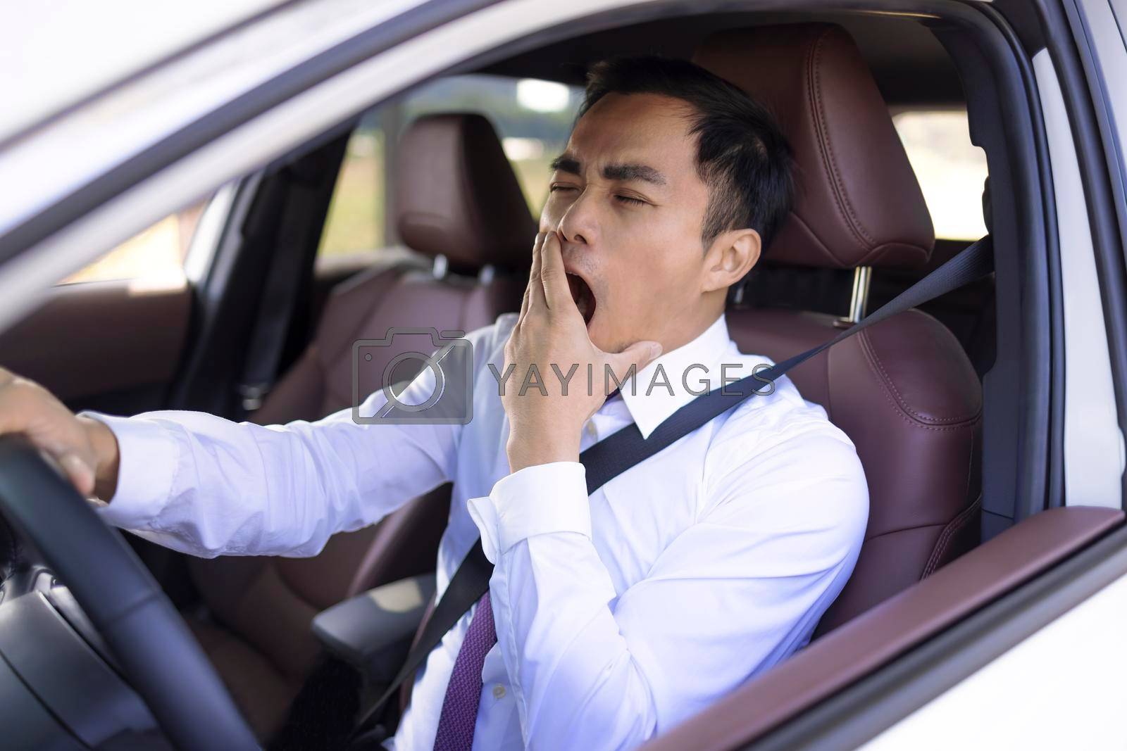 Royalty free image of Business man looks tired yawning while driving the car by tomwang