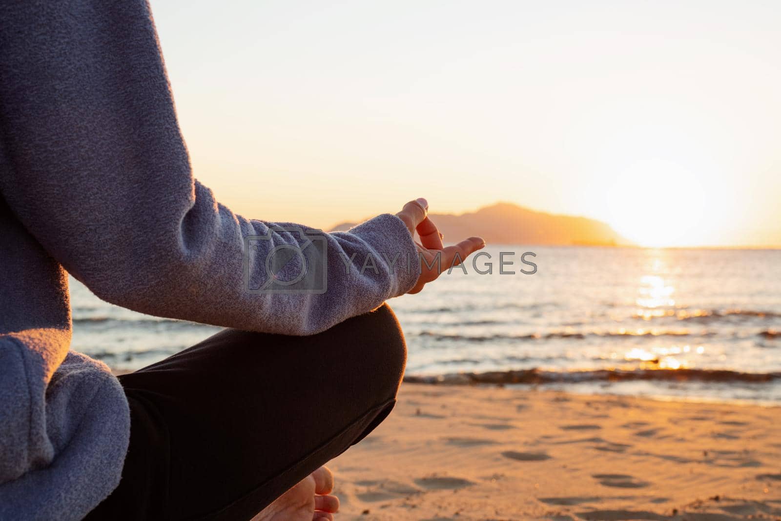 Health and wellness. Young healthy woman practicing yoga on the beach at sunset