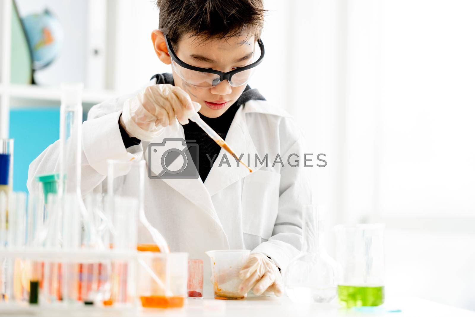 Royalty free image of School boy in chemistry class by tan4ikk1