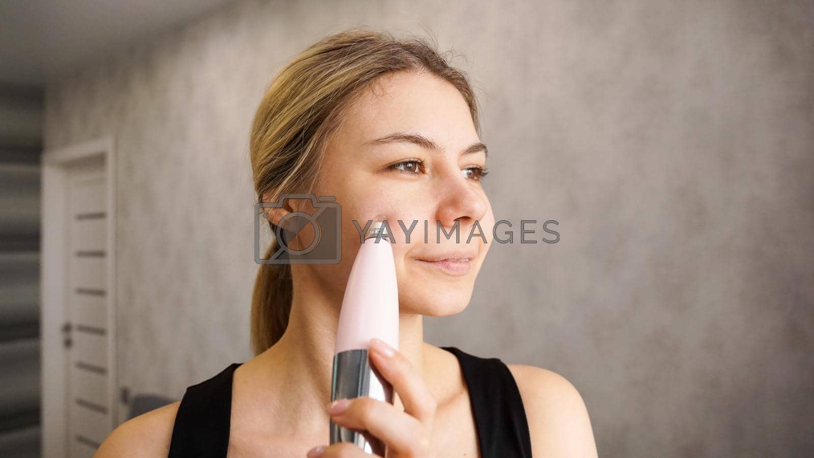 Royalty free image of Beautiful woman is using vacuum device for removing blackheads by natali_brill