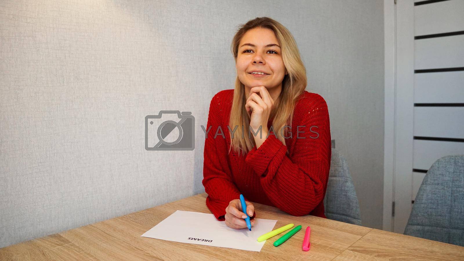 Royalty free image of Portrait of young beautiful thoughtful lady writing down her dreams list by natali_brill