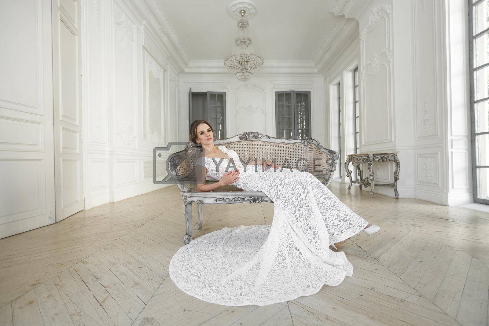Royalty free image of Beautiful bride posing in wedding dress in a white photo Studio. by StudioPeace