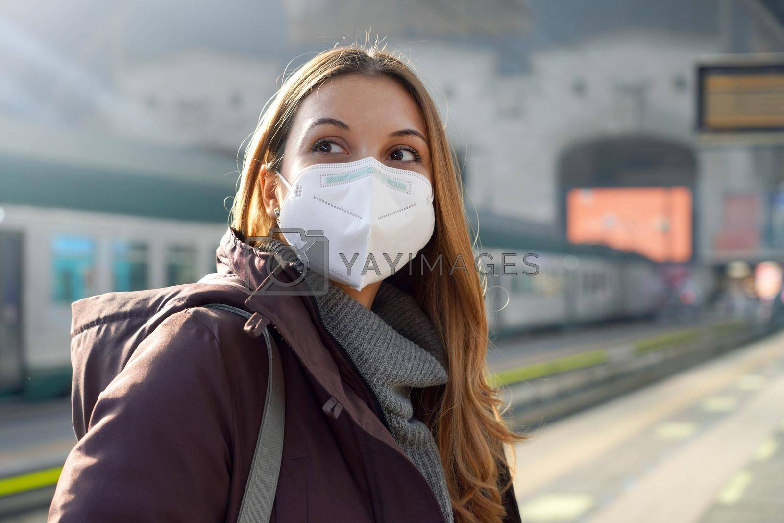 Royalty free image of Portrait of casual woman waiting train with KN95 FFP2 protective mask at train station on winter by sergio_monti