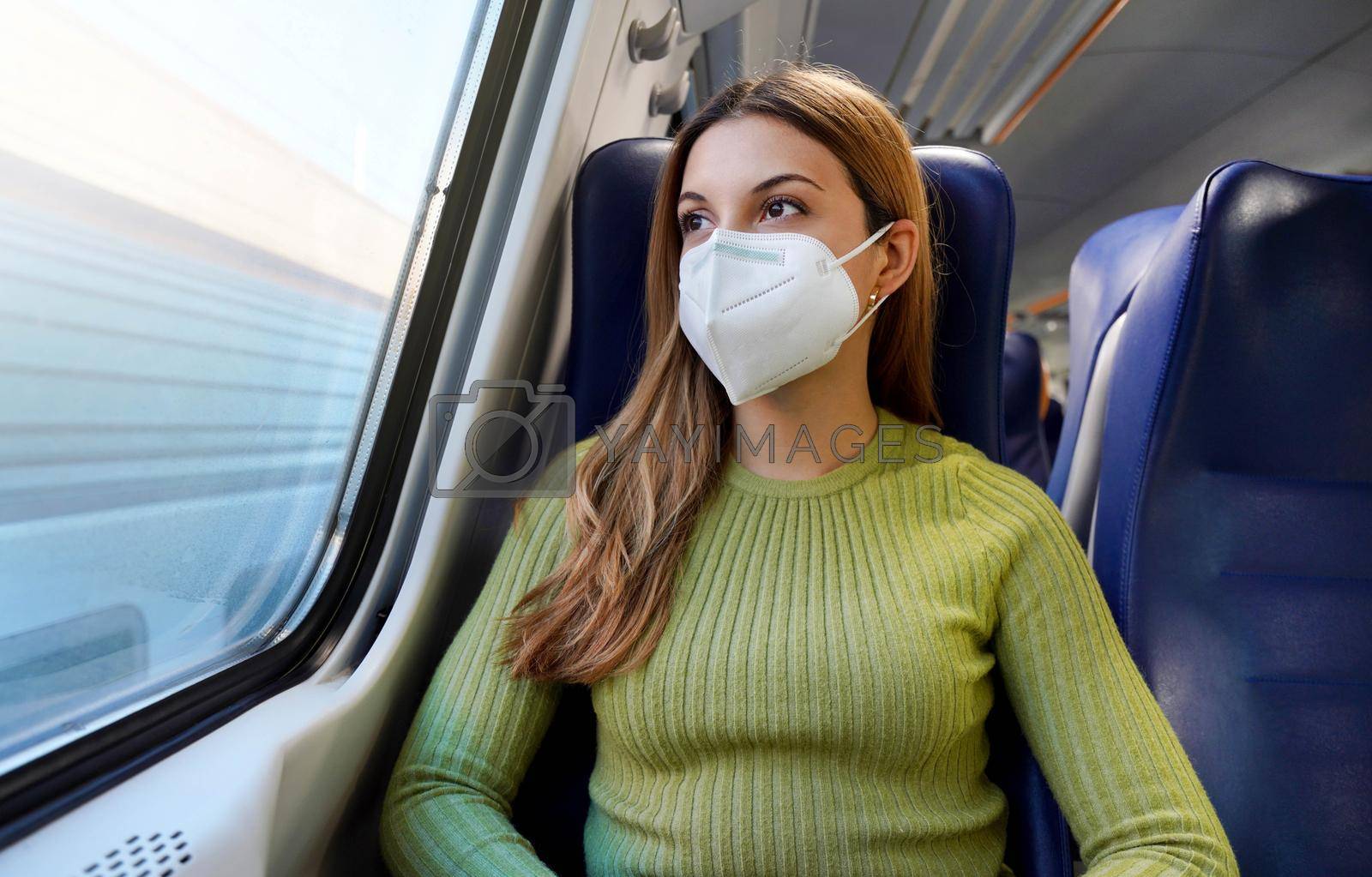 Young business woman wearing a protective mask sitting relaxed in the train