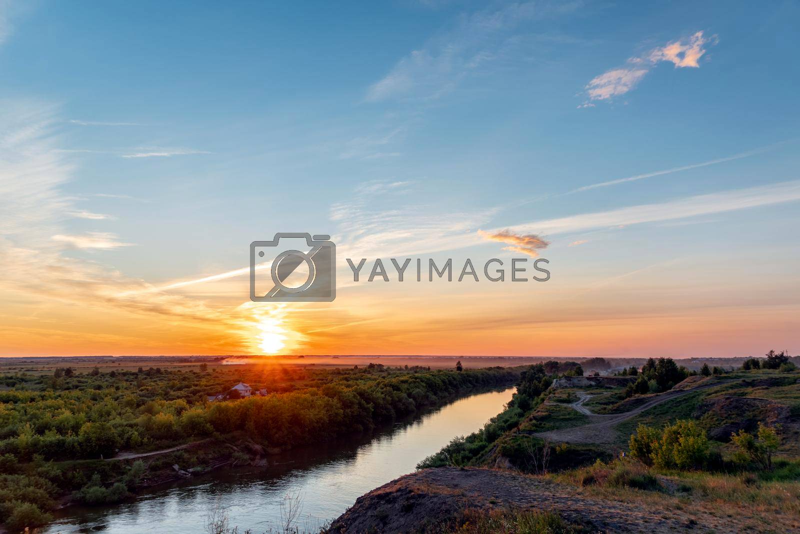 Royalty free image of The heavenly light of the sun over the river and the forest.Dramatic evening sky with clouds and rays of the sun.Golden hour at evening sunset or morning sunrise.Panoramic view of cirrus clouds by YevgeniySam