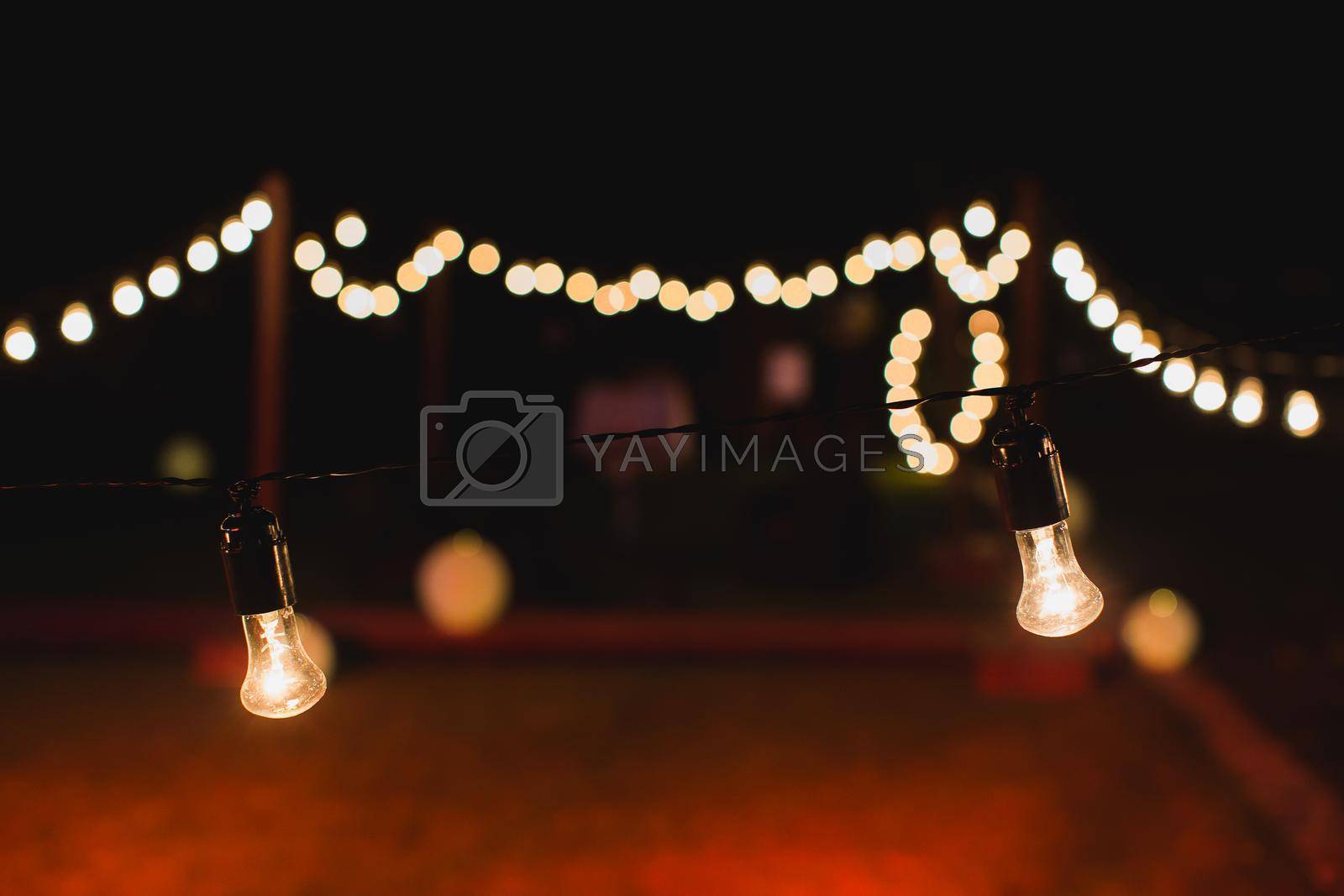 Royalty free image of outdoor string lights hanging on a line in backyard. by StudioPeace