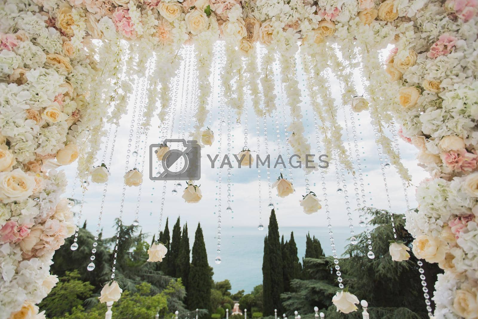 Royalty free image of Wedding arch with flowers and beads on blue sky background close-up by StudioPeace
