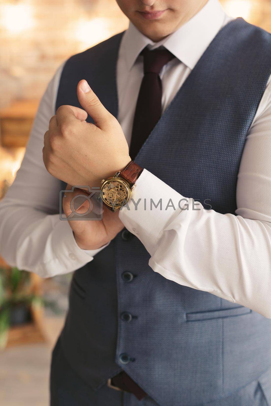 Royalty free image of Close-up hands of the groom with a clock. by StudioPeace