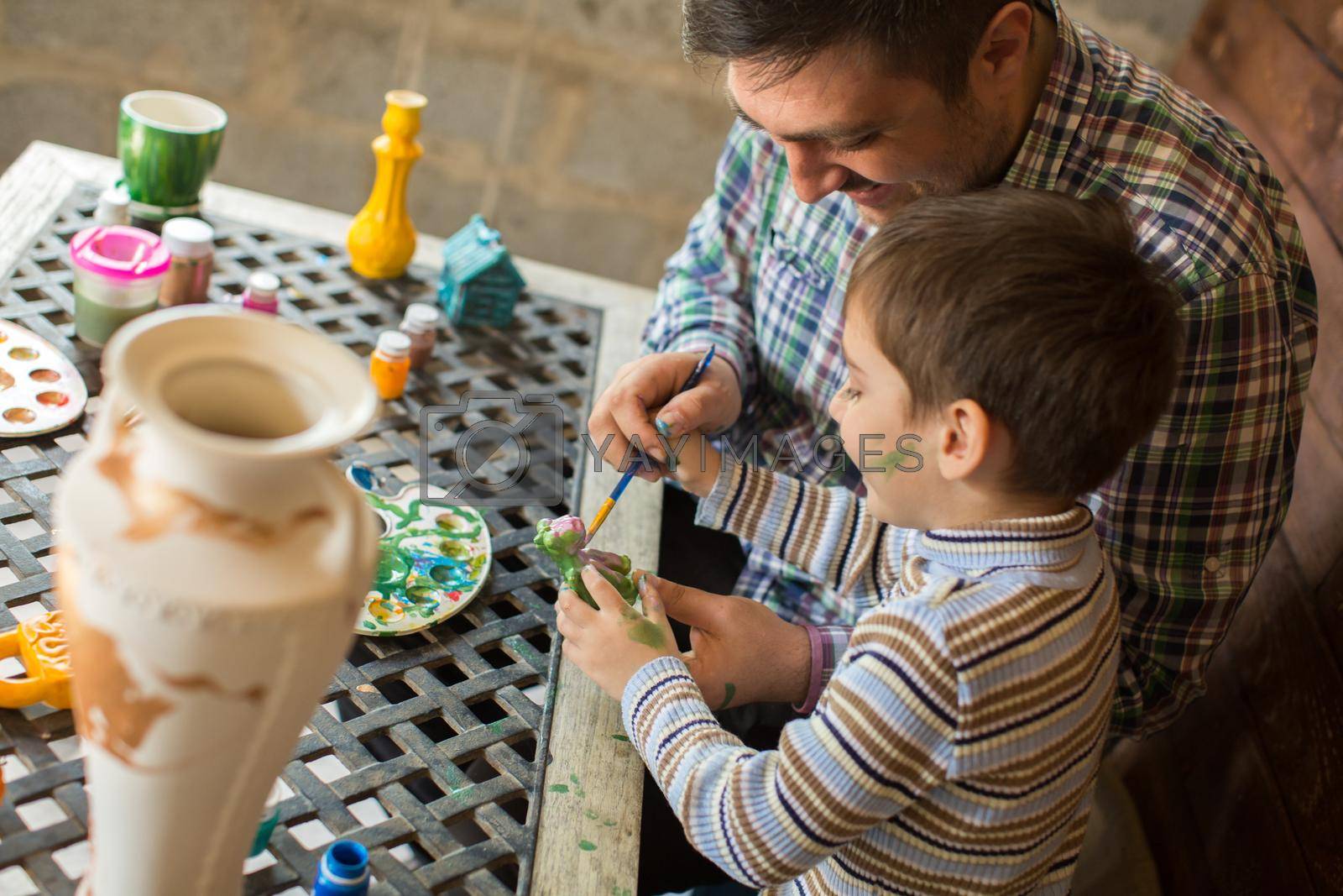 Portrait of a father and son who will decorate a vase.