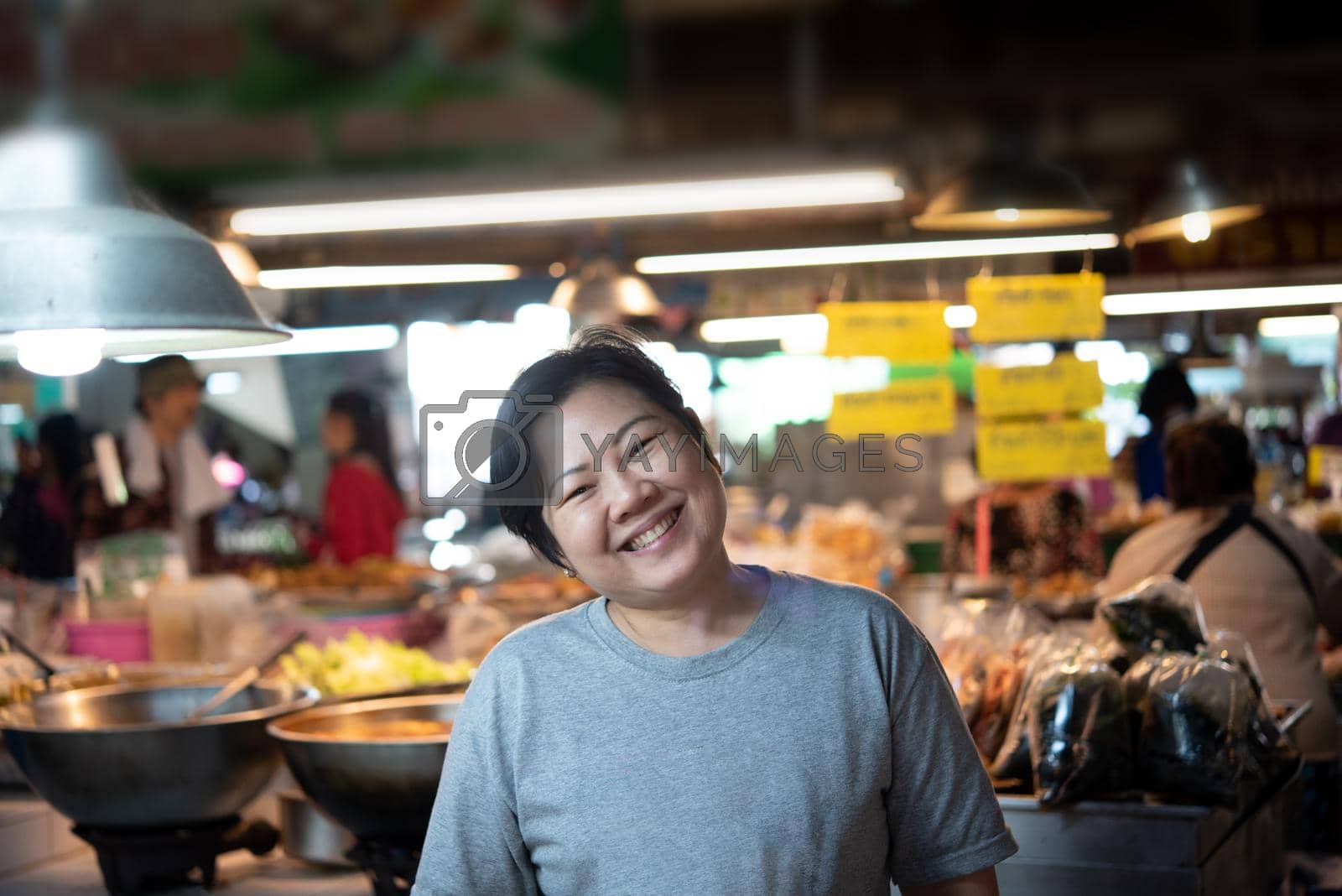Woman at Thai street food with curry and rice shop in market