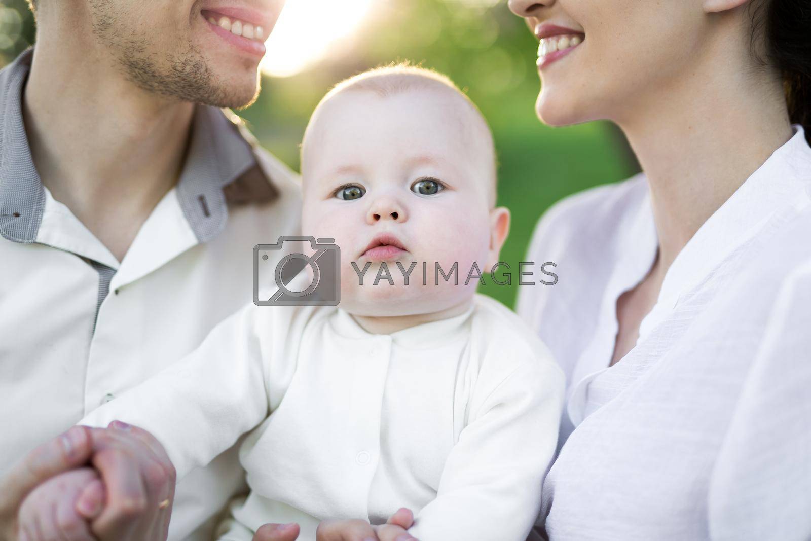 Portrait Beautiful Mother, Father And Baby outdoors. Happy family on a summer meadow